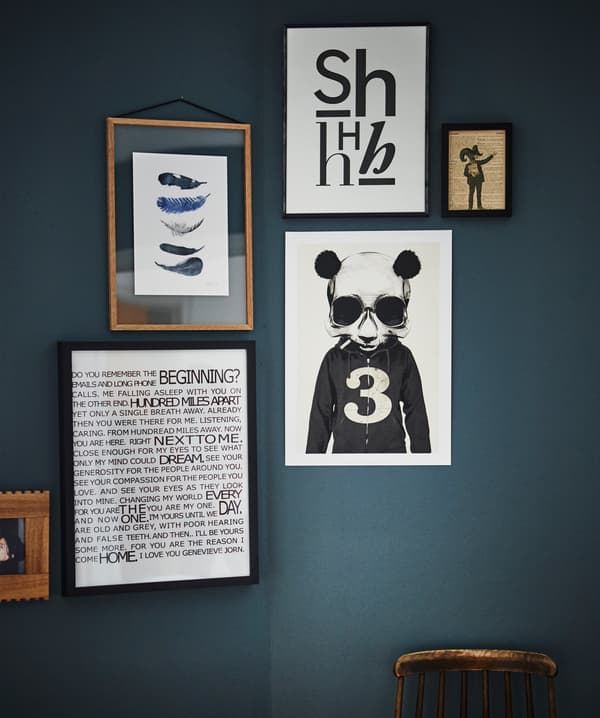 Framed graphic artwork hangs against a dark wall.