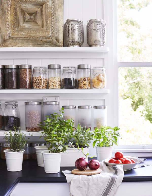Fresh herbs in pots on the kitchen worktop.