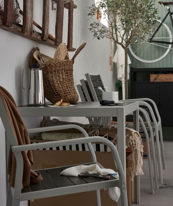 Garage-like interior with stacked outdoor chairs and a single chair placed beside the table.