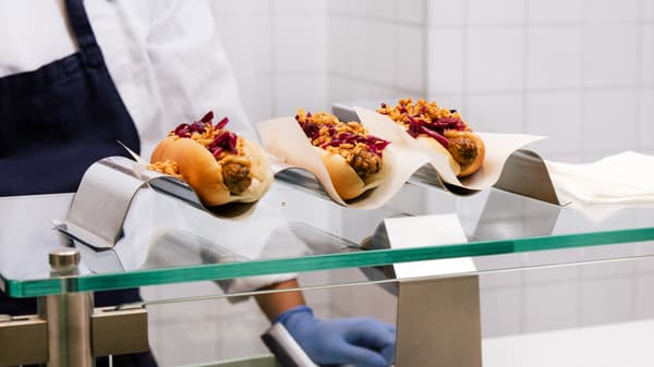 ガラスケースに並ぶトッピング付きホットドッグ3本。