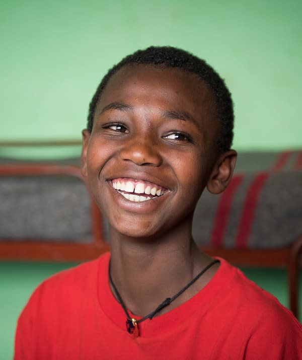 Garçon en T-shirt rouge, souriant.