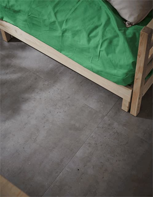  GIF d’une boîte de rangement sur roulettes sortant d’en dessous du lit, dans une chambre d’étudiant.