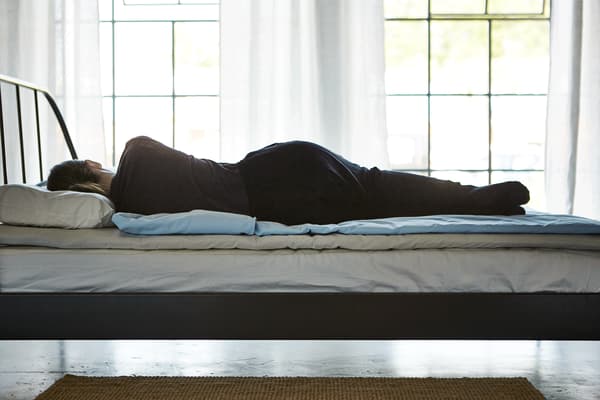 GIF montrant une femme changeant de position sur son lit : sur le côté, sur le dos, sur le ventre.