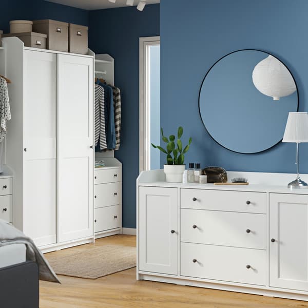 Grande armoire-penderie HAUGA en blanc avec portes coulissantes et commode HAUGA à 6 tiroirs.