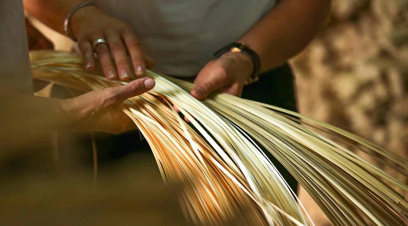 Green and yellow bamboo material held by two people.