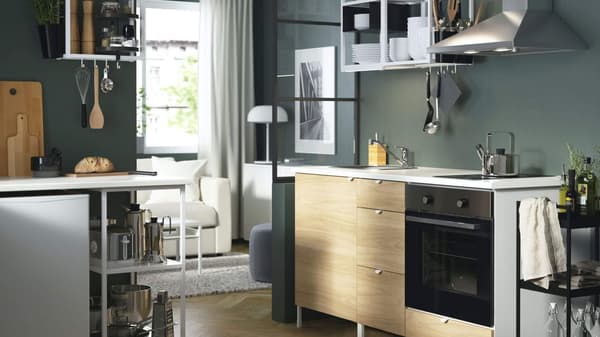 Green kitchen with light wood cabinets