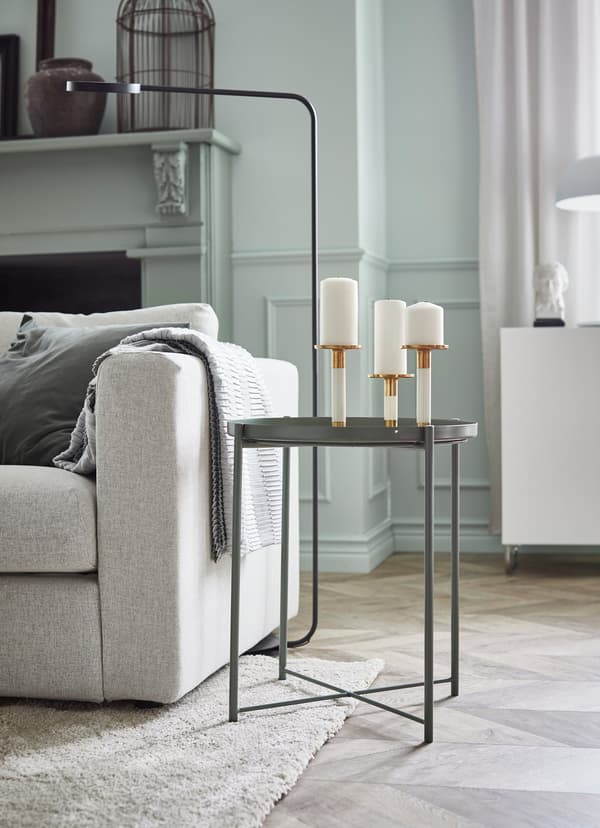 Grey coffee table with three candle holders on top.