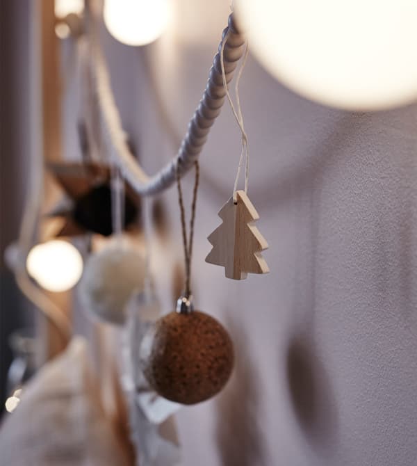 Gros plan de décorations et de guirlandes lumineuses accrochées à la tête d'un lit.