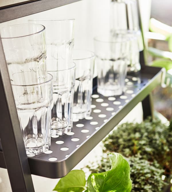 Gros plan de verres empilés sur une tablette, sur un balcon.