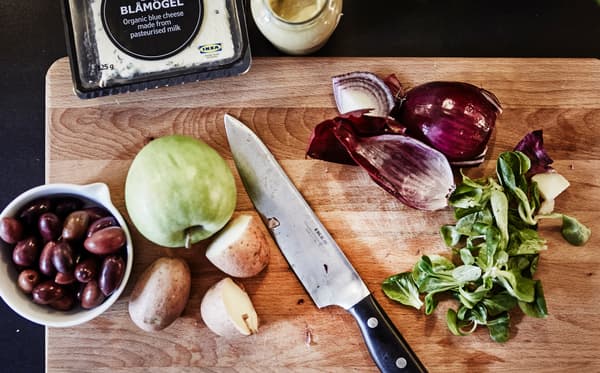 Gros plan d’un filet d’huile d’olive versé dans un saladier blanc.