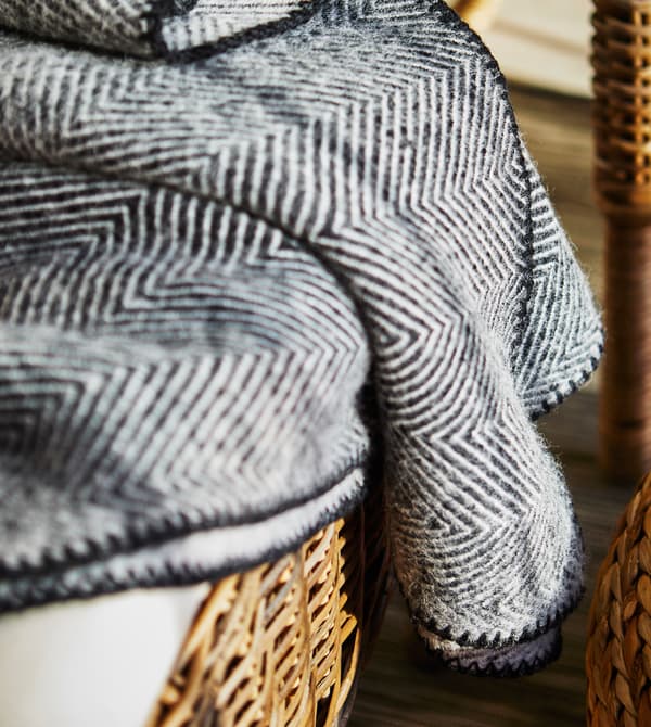 Gros plan d’un plaid noir et blanc sur un fauteuil.