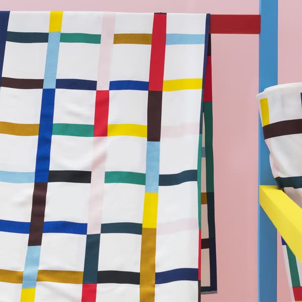 Gros plan d’un tissu à motifs multicolores pendu sur une barre.