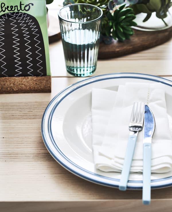 Gros plan d’une déco de table, avec assiette, serviette, couteau et fourchette.