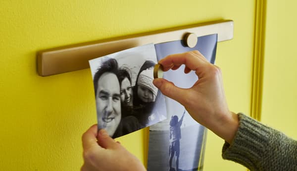 Gros plan d’une personne en train de placer une photo sur un rail pour couteaux magnétique.
