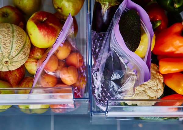Gros plan sur deux bacs à légumes ouverts, avec fruits dans l’un et légumes dans l’autre.