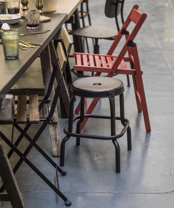 Gros plan sur le bord d'une table assortie de chaises dépareillées.