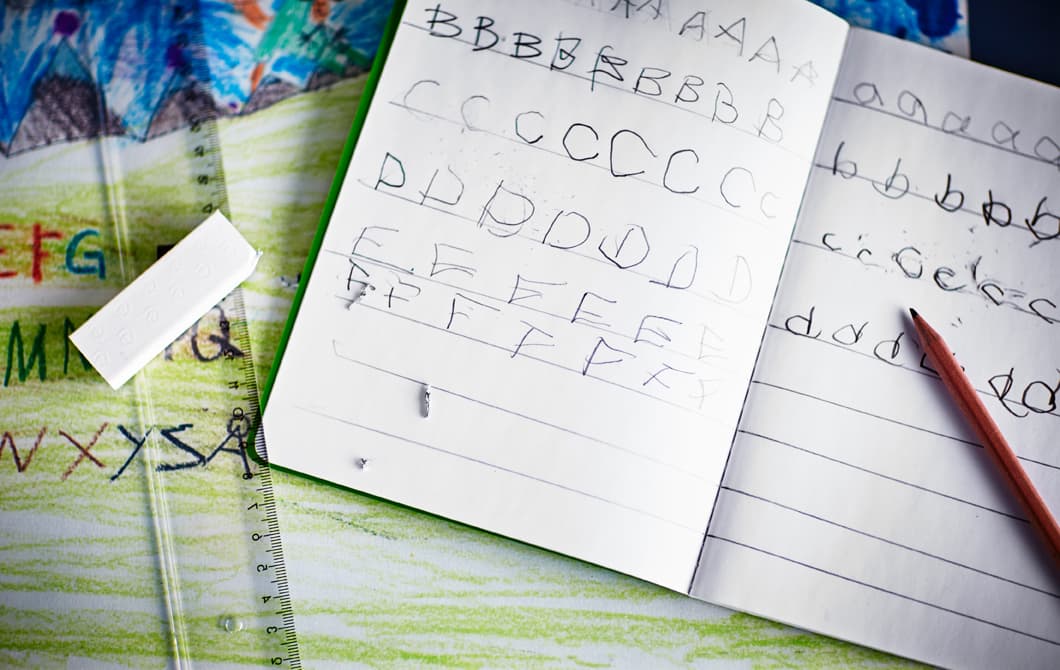 Gros plan sur un calepin où on voit l’écriture d’un enfant.