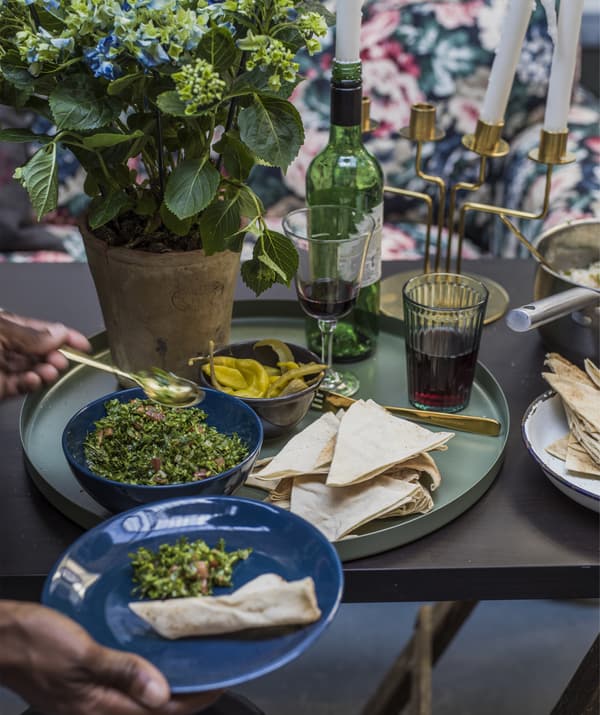 Gros plan sur une table à manger, un plateau vert et des bols de nourriture.