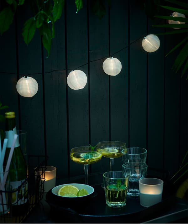 Guirlande lumineuse IKEA SOLARVET suspendue au-dessus d’une sélection de verres.