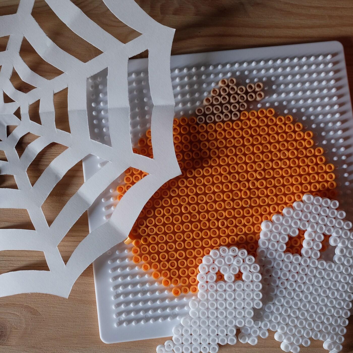 Halloweenpyssel med pärlor som ska likna en pumpa och två spöken.