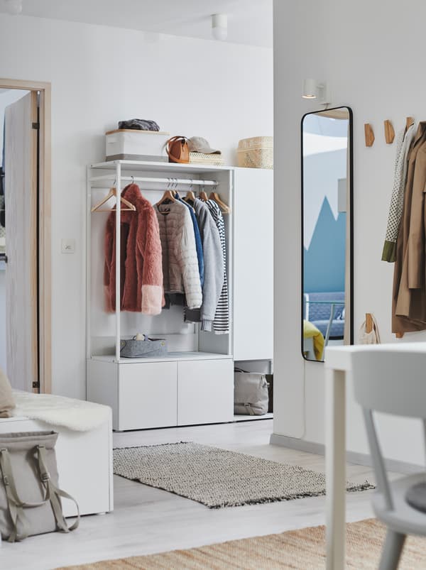 Hallway interior with spread out stations for hanging or storing clothes, including a white PLATSA wardrobe.