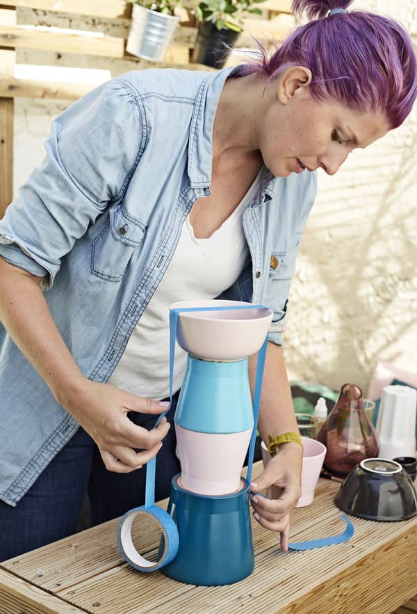 Hester fastens the pots with tape.
