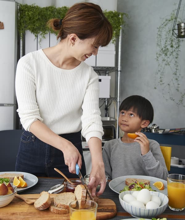 Hiromi and her son preparing breakfast at the table.