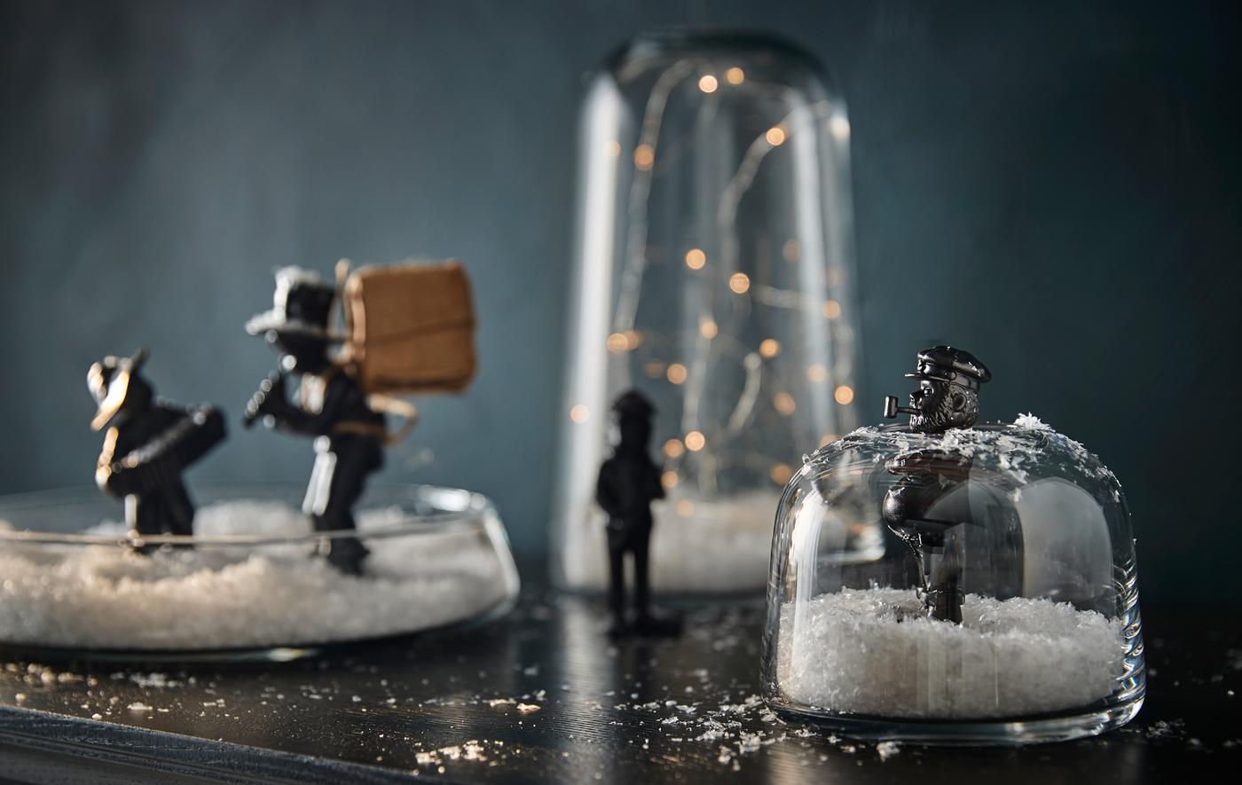Home-made snow globes made using IKEA glass jars and vases, with lights, fake snow and figurines inside.