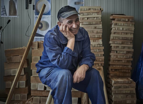 Homme en bleu de travail, dans un atelier.