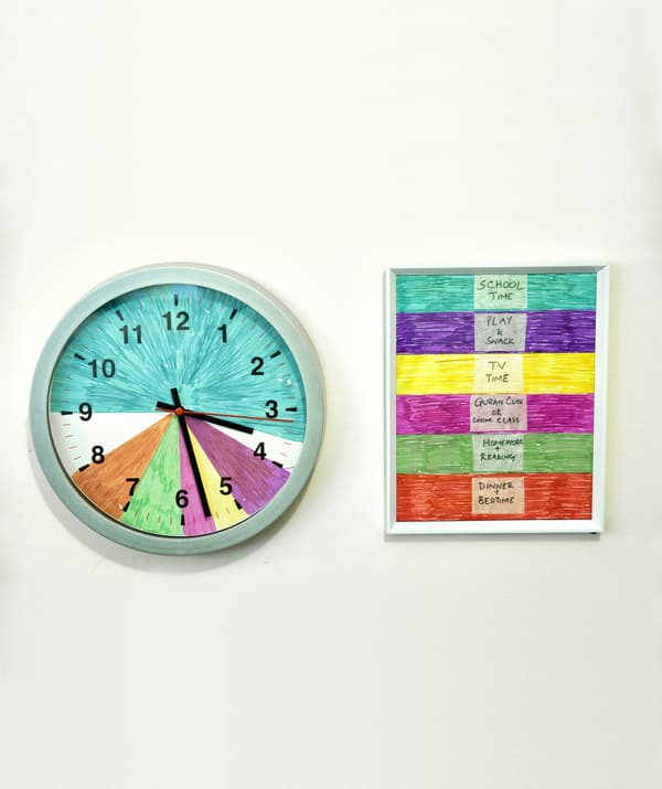 Horloge murale divisée en segments colorés, à côté d’un code de couleur pour les activités familiales.