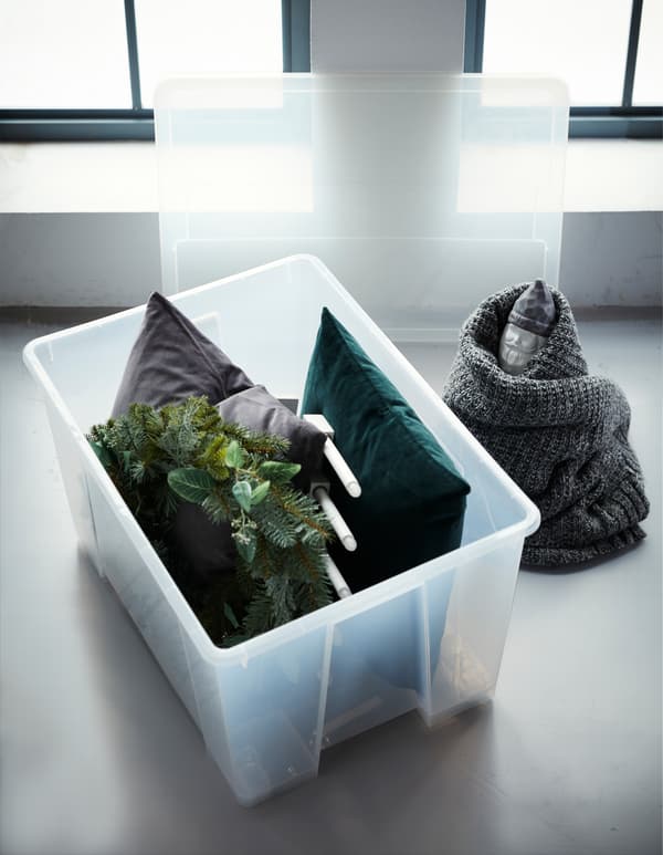 Idées pour ranger les décorations une fois le temps des Fêtes terminé. Les articles volumineux trouvent leur place dans une boîte. Les coussins absorbent les chocs et protègent les éléments les plus fragiles. IKEA propose des boîtes grand format dans la collection SAMLA en plastique transparent. 