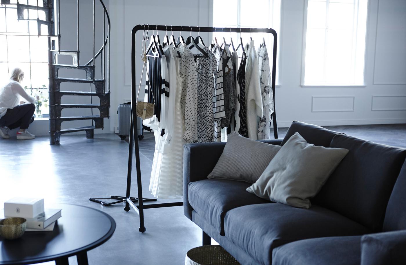 If you have guests staying on a sofa bed, a clothes rack serves double duty as a room divider and a place to unpack clothes.