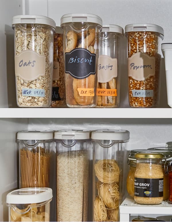 IKEA 365+ dry food jar containers with oats, biscuits, and cereal, inside a white kitchen cabinet.