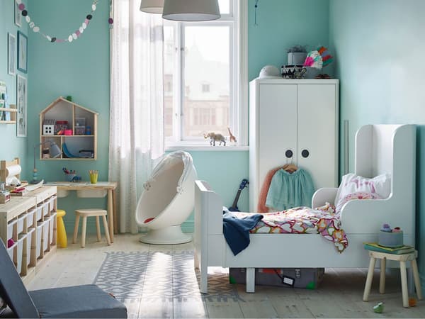 IKEA BUSUNGE white extendable bed in a teal wall coloured children's bedroom.