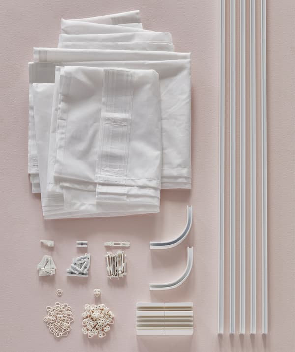 IKEA can has a track rail system called VIDGA to mount curtains to the ceiling. To surround a bed that’s against a wall, you need single tracks, corner pieces, ceiling fittings, gliders/hooks, a cutting box and curtains. All VIDGA parts are white.