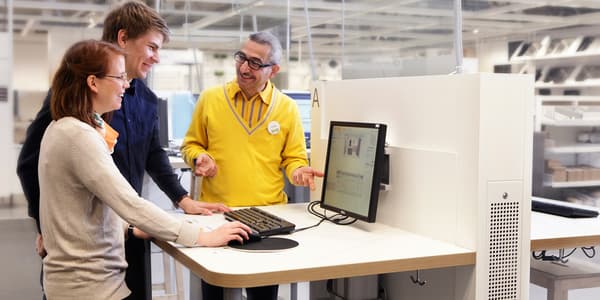 IKEA co-worker assisting customers plan a PAX wardrobe.