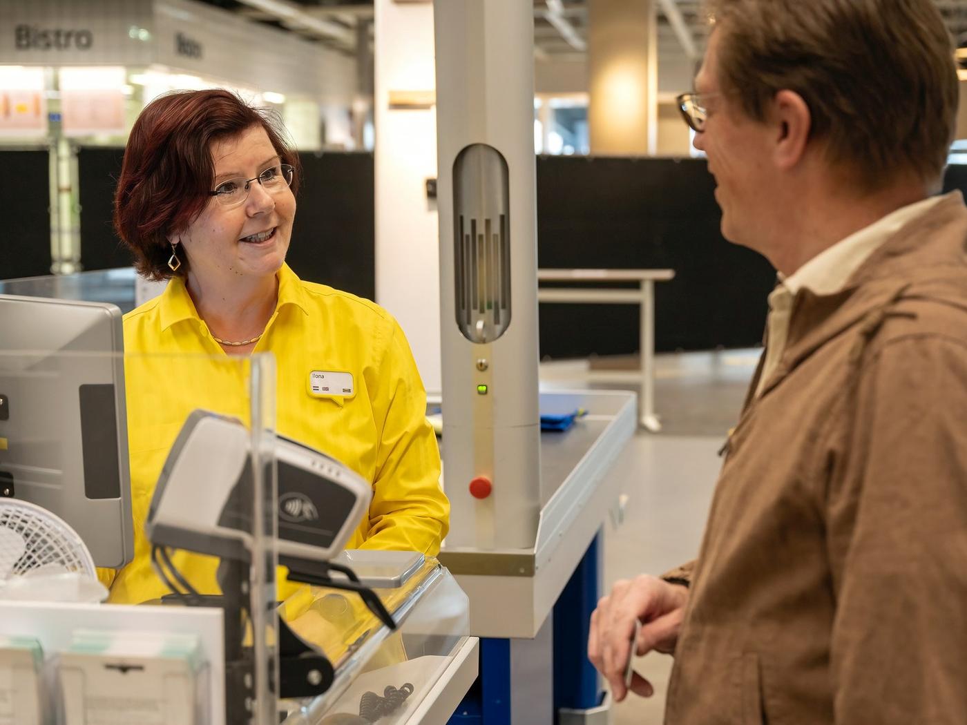 IKEA co-worker serving a customer at checkout