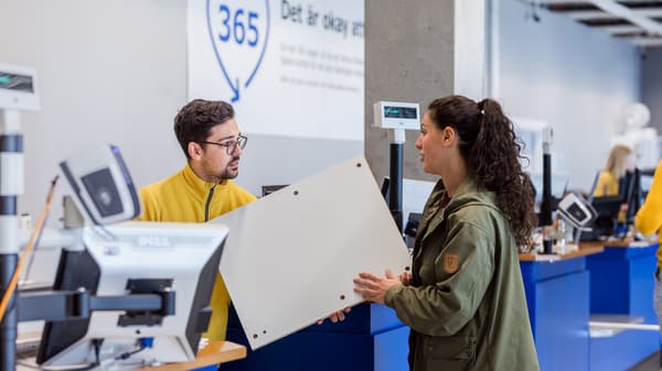 IKEA co-worker speaking to a customer by the counter. 