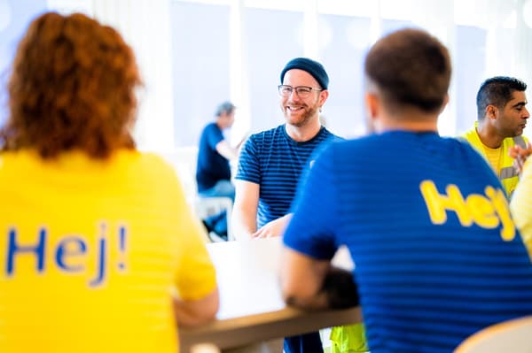 IKEA co-workers in dark blue uniforms arrange dishes on plates in the Swedish restaurant.