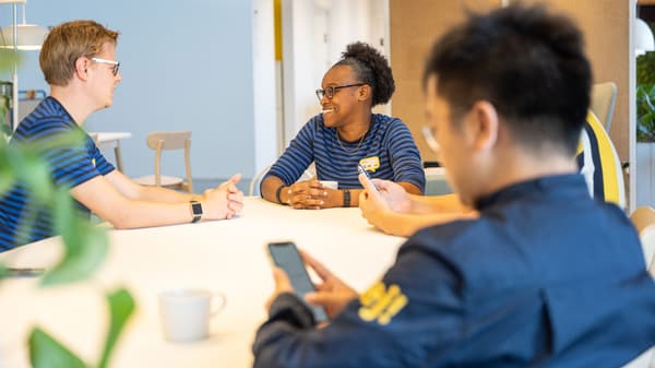 IKEA co-workers wearing dark blue uniforms plating up meals in the restaurant.