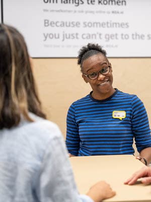 Ikea customer service employyee smiling at the customer in front of her