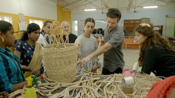 IKEA designers and Indian women artisans discussing weaving techniques on the factory floor.