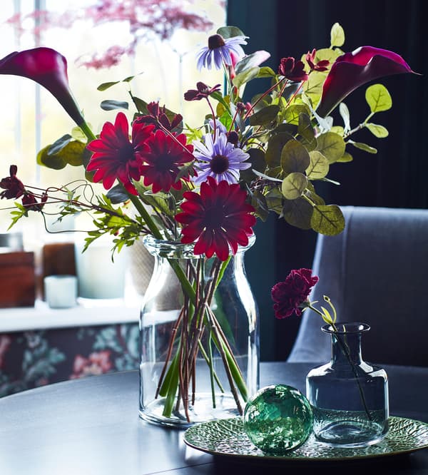IKEA FEJKA red and purple fake flowers in a BEGÄRLIG glass vase.