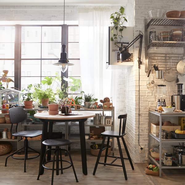 IKEA GAMLARED Tisch Antikbeize hell/schwarz gebeizt hat schwarze Beine und eine runde Tischplatte mit sehr glatter Oberfläche.