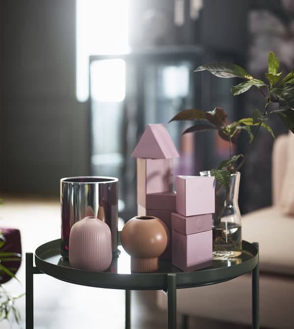 IKEA has a variety of pink and green decor for your living room like rugs, sofas, vases and cushions. Resting on a green tray table are two GRADVIS vases in natural and pink stoneware with round, organic shapes.