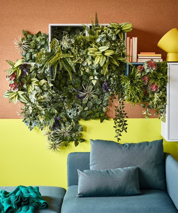IKEA has lots of artificial flowers and plants if you lack sun or plant skills. FEJKA artificial potted plant fern in plastic can be used indoors or outdoors and wipes clean. Above a sofa, we created a green wall with the fern and other fake plants.