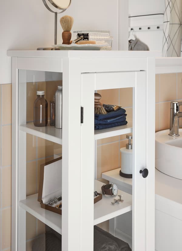 IKEA HEMNES high glass cabinet is crafted from tempered glass, with a white powder coated frame. Its compact size makes it ideal for small space bathrooms.