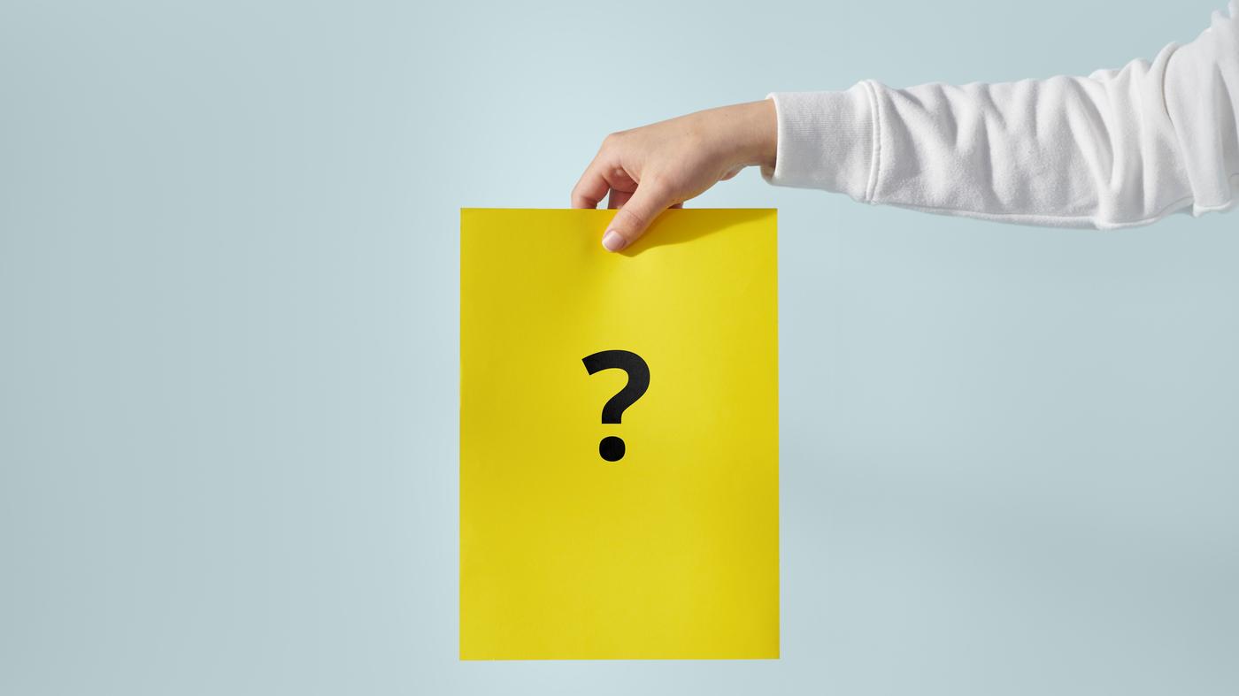유니폼을 입은 IKEA 직원이 노란색 IKEA 가방을 들고 IKEA 매장 계단을 내려오며 고객에게 인사하는 모습.