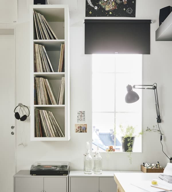 IKEA KALLAX open shelving unit stores vinyl records in a white workspace.