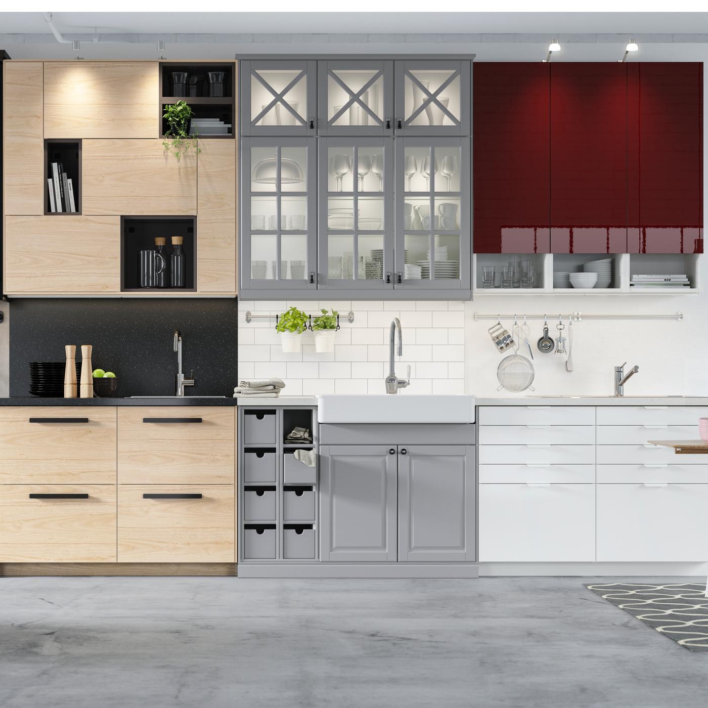 IKEA kitchen solution, with wooden fronts and grey and white fronts on the base and wall units, the wall unit on the far right has red fronts.